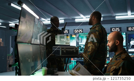 Military officer using tracking software on laptop to gain info helpful against enemies. Army professional using notebook to gain intel helping troops, coordinating mission activities, camera B 121735250