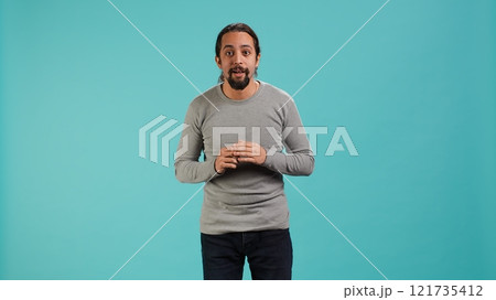 Portrait of wide eyed man looking in awe, captivated by what he sees, isolated over studio background. Excited curious person being in complete admiration, unable to believe eyes, camera A 121735412