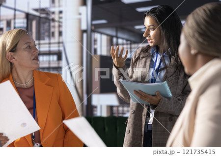 Multiethnic women executives uniting forces in a collaborative meeting, focused on data management and business development. Experts with leadership skills fighting for empowerment. 121735415