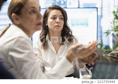 Forecast affiliates in a multinational company collaborating around a conference table, brainstorming new ideas for global expansion and refining a new marketing strategy. Data management. 121735444