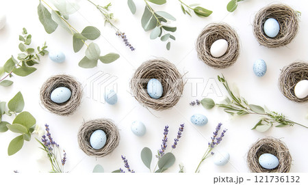 A softly styled arrangement of robin eggs nestled in small nests, framed by eucalyptus leaves and lavender in a serene spring setting 121736132
