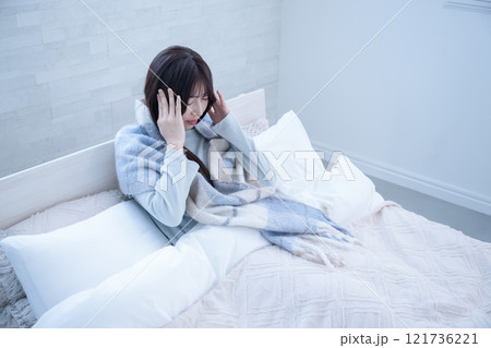 ストレスで頭を抱えてしまうベッドから起き上がれない女性 ストレスで頭を抱えてしまうベッドから起き上がれない女性 121736221