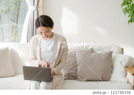 リビングでパソコンを使う女性 リビングでパソコンを使う女性 121736336