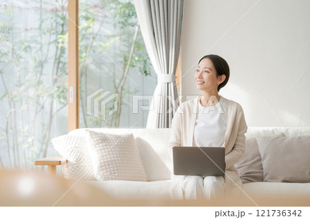 リビングでパソコンを使う女性 121736342