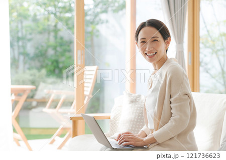 ソファでパソコン作業をする女性 ソファでパソコン作業をする女性 121736623