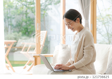 ソファでパソコン作業をする女性 121736625
