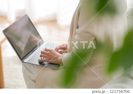 ソファでパソコン作業をする女性 121736700