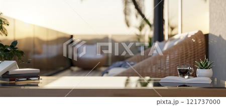 A coffee table features books, a coffee cup, and decorative plants on an apartment balcony. 121737000