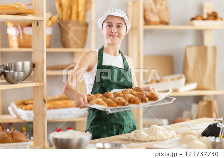 Teen girl holding croissants in square wicker basket Teen girl holding croissants in square wicker basket 121737730