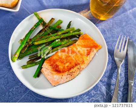 Grilled salmon filet with asparagus on plate 121737813