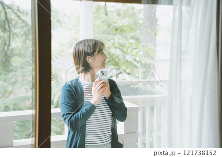 ベランダで音楽を聴く若い女性 121738152