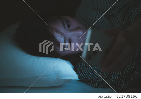 寝ながらスマホとブルーライト 121738166