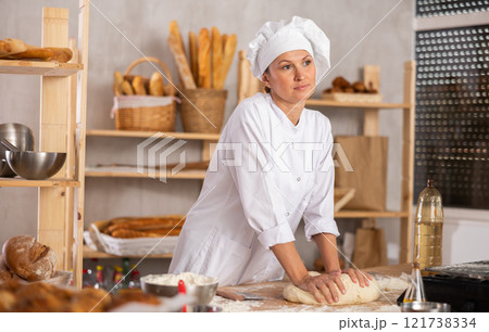 Professional baker kneading dough 121738334
