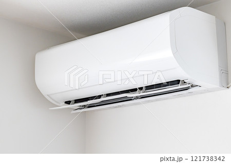 ルーバーを上に向けた白い大型のエアコン 121738342