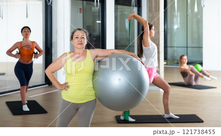 Mature female performing set of exercises with pilates ball Mature female performing set of exercises with pilates ball 121738455