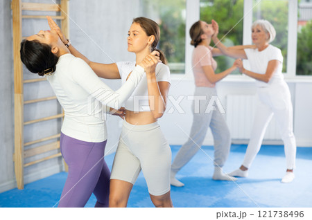 Young woman practicing palm strike to chin during sparring at self-defense course Young woman practicing palm strike to chin during sparring at self-defense course 121738496