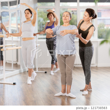 Ballet choreographer instructing senior woman in basic ballet techniques Ballet choreographer instructing senior woman in basic ballet techniques 121738563