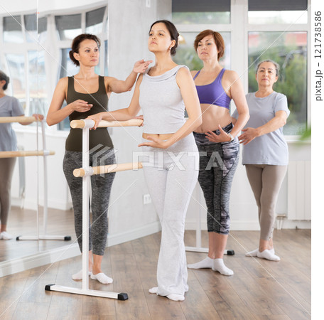 Adult woman teacher correcting beginning dancers 121738586