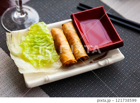 Fried spring rolls served with lettuce 121738599