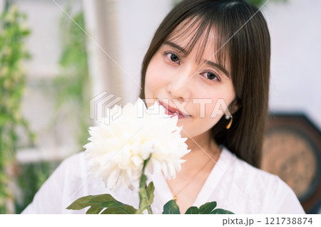 白い花を持つ黒髪ロングヘアの若い女性 白い花を持つ黒髪ロングヘアの若い女性 121738874