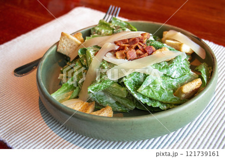 fresh green caesar salad with bacon and cheese on top fresh green caesar salad with bacon and cheese on top 121739161