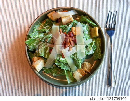 fresh green caesar salad with bacon and cheese on top fresh green caesar salad with bacon and cheese on top 121739162