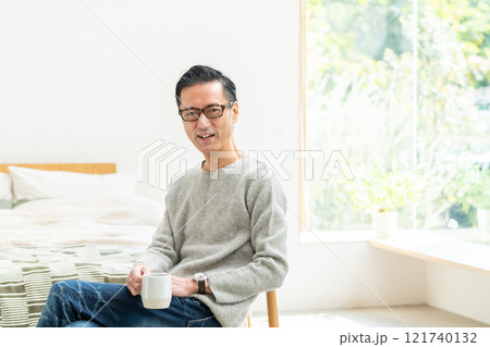 ベッドルームでコーヒーを飲むミドル男性 121740132