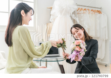 ウェディングプランナーと結婚式のブーケ・花束選びの打ち合わせをする女性 ウェディングプランナーと結婚式のブーケ・花束選びの打ち合わせをする女性 121740799