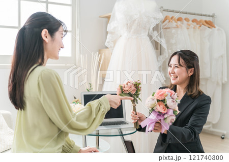 ウェディングプランナーと結婚式のブーケ・花束選びの打ち合わせをする女性 ウェディングプランナーと結婚式のブーケ・花束選びの打ち合わせをする女性 121740800