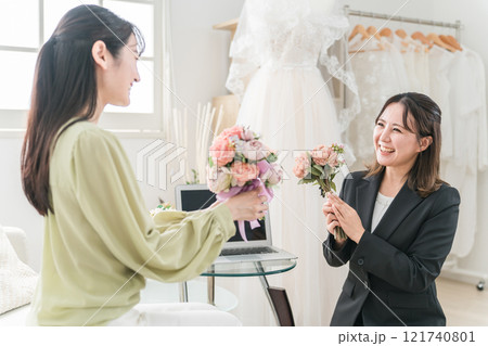 ウェディングプランナーと結婚式のブーケ・花束選びの打ち合わせをする女性 ウェディングプランナーと結婚式のブーケ・花束選びの打ち合わせをする女性 121740801