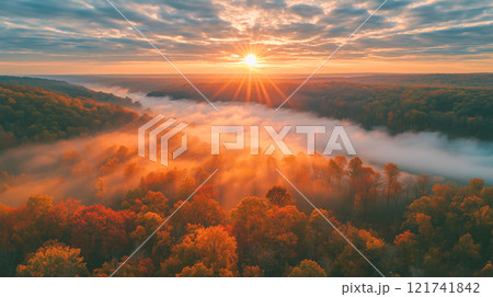 霧のかかった丘と燃えるような秋の木々が広がる雄大な川の渓谷 121741842