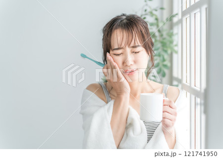 虫歯が痛い・しみて頬を押さえるアジア人女性 121741950