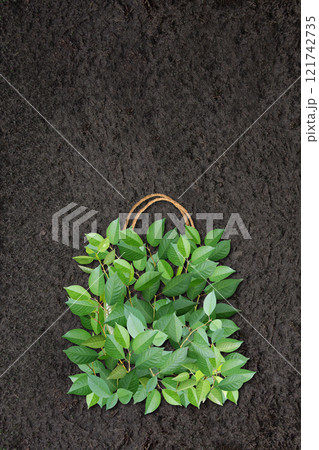 Vertical Eco background with soil and shopping bag made from green leaves. Responsible consumption. Eco-friendly agricultural business. Ecology and zero waste concept. Copy space for text 121742735