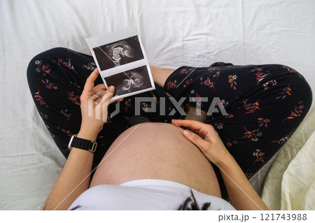 Pregnant Woman Holding Ultrasound Images 121743988