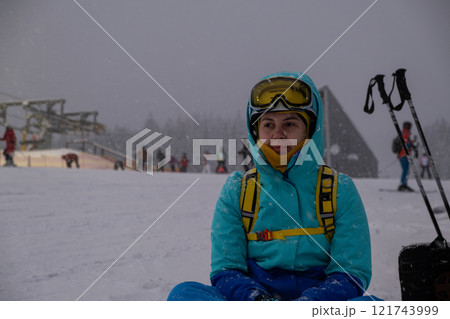 Skier Resting on Snowy Slope at Ski Resort 121743999