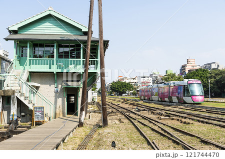 The circular light rail train drives past the former Kaohsiung Port Station North Signal Box, Taiwan. 121744470