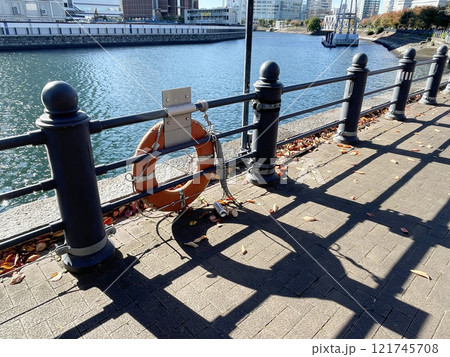 A lifebuoy hangs on a fence on an embankment in Japan 121745708