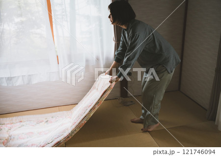 敷布団を敷く女性 敷布団を敷く女性 121746094