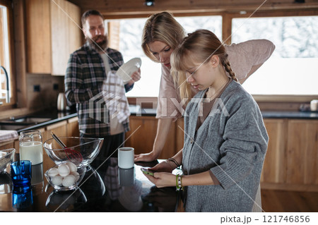 Family making pancakes, looking for recipe on smartphone. Family making pancakes, looking for recipe on smartphone. 121746856