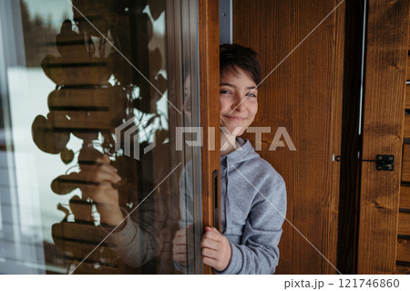 Cute girl standing on balcony and looking at snowfall. Cute girl standing on balcony and looking at snowfall. 121746860