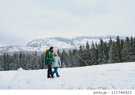 Dad and girl in the middle of snowy nature. Hiking in winter mountains. Winter family walk. 121746922