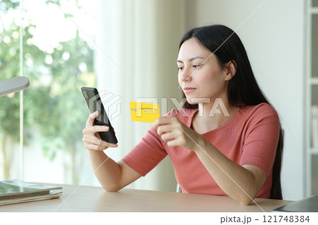Serous asian woman buying online in a room Serous asian woman buying online in a room 121748384