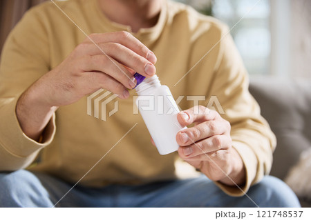 Man holding jar with empty space, filled with vitamins, dietary supplements for health. Strengthening immune system. Man holding jar with empty space, filled with vitamins, dietary supplements for health. Strengthening immune system. 121748537
