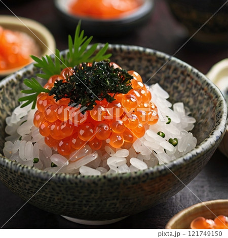 Bowl of rice topped with salmon roe garnished with seaweed and herbs.  121749150