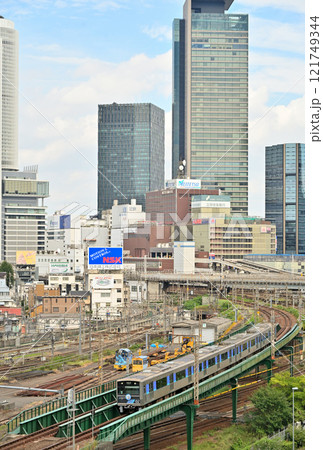名古屋駅のビル群を背景に走るあおなみ線20周年記念の電車 121749344
