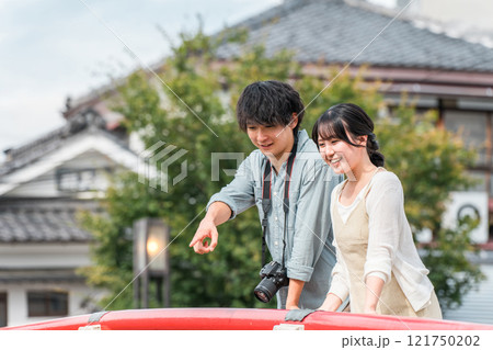 国内旅行で城下町を街歩き・観光ツアーをする若い夫婦・カップル 121750202