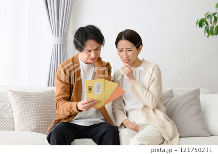 督促状を見て困る男女 121750211