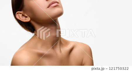 Close-up of woman's neckline and jawline, highlighting her smooth skin and natural elegance against white studio background. Concept of natural beauty. 121750322