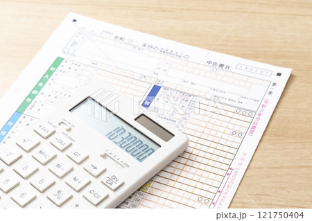 机に置かれた確定申告書類と電卓 机に置かれた確定申告書類と電卓 121750404