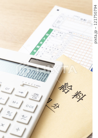 机に置かれた確定申告書類と電卓と給料袋 机に置かれた確定申告書類と電卓と給料袋 121750794